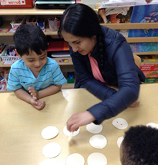 A mother and a group of children play Memory Match during a Monthly Math Morning.